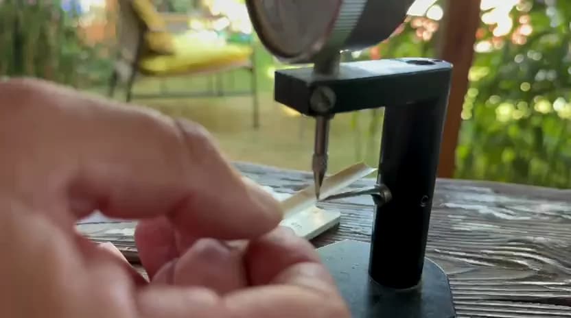 A craftsperson measuring the thickness of gouged oboe cane by hand